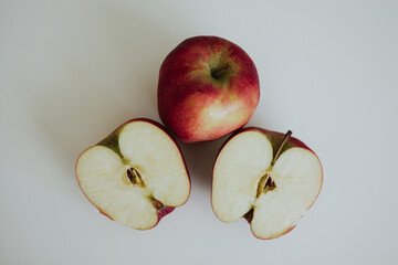 red full and cut in half apples on white background