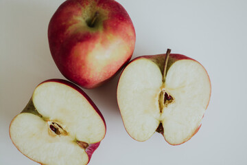 macro shooting of red full and cut in half apples on white background