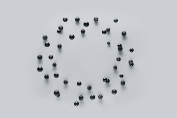 Frame made of blackcurrant flying on grey background