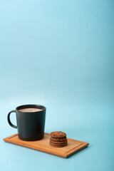 The chocolate chip cookie biscuit with a cup of chocolate on a blue background. 