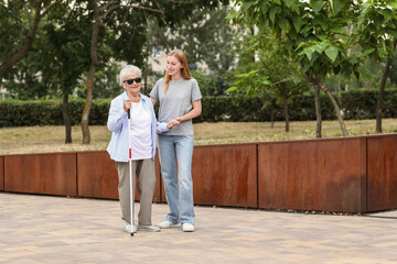Young woman with blind grandmother in park