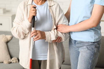 Young woman with blind grandmother at home, closeup