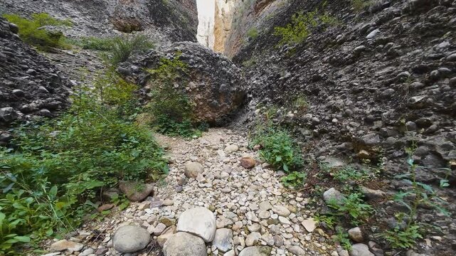 Aerial-FPV-Flying close under huge chock stone boulder blocking the trail and then onto end of the box canyon in Maple Canyon, Utah USA. The conglomerate structure makes for world class rock climbing 
