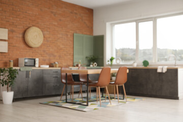 Blurred view of kitchen with black counters and dining table