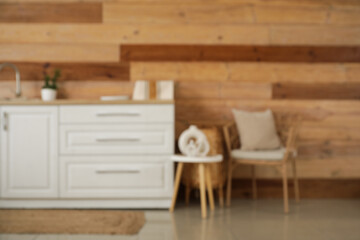 Blurred view of kitchen with white counters and armchair