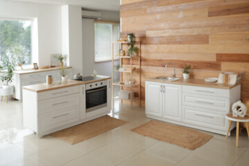 Blurred view of kitchen with white counters and shelf unit