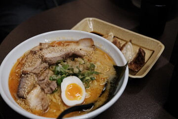 Warm ramen broth with chashu and gyoza