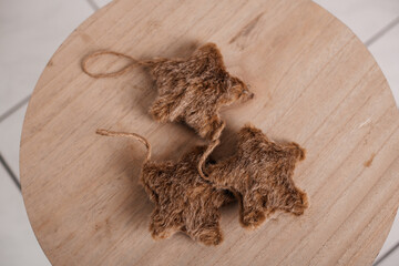 A set of rustic burlap star ornaments displayed on a wooden surface.