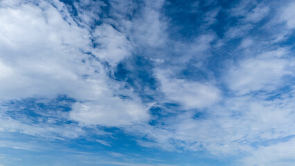 View of clouds floating on blue sky. During the day the sky looks blue because it's the blue light that gets scattered the most.