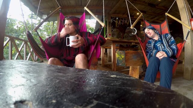 A couple swings on the hammock chairs in a hostel at Semuc Champey, Guatemala