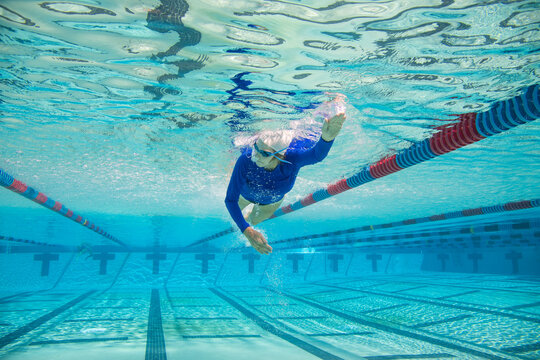 Close-up underwater shot of a senior woman swimming front crawl in a swimming pool