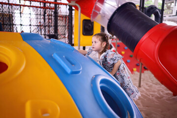 Cute girl having fun playing on playground equipment.