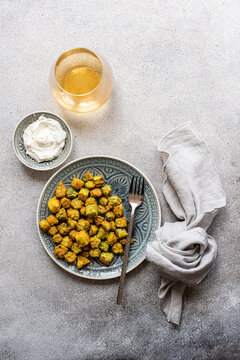 Overhead view of fried okra with a sour cream and garlic dipping sauce and a glass of white wine