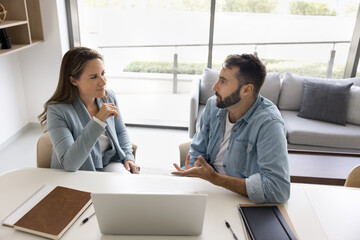 Couple of office colleagues discussing work project, job case at workplace, meeting at laptop for...