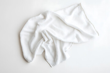 A white towel is laying on a white surface