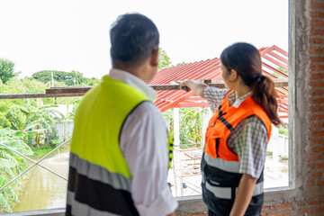 Female and male construction worker working in house under construction. construction concept of engineering working on site work.