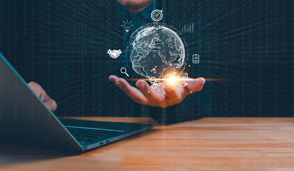Businessman holding digital globe with technology and data icons over laptop. Conceptual technology and global innovation