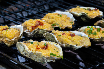 Baked oysters with garlic and parsley on the grill.