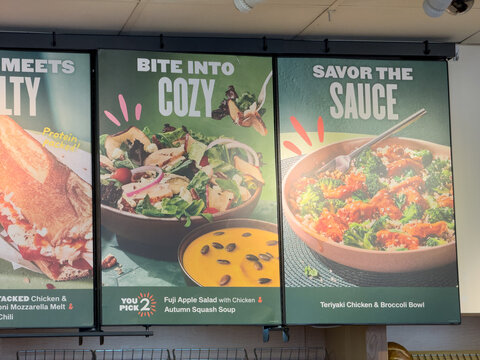 Panera Bread restaurant menu items on display inside a cafe.