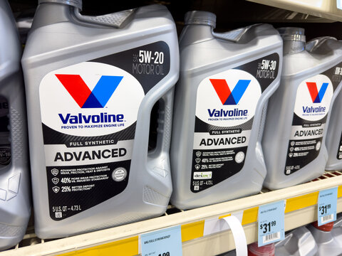 Containers of Valvoline advanced 5W-20 car motor oil on market shelf inside Napa Auto Parts store.