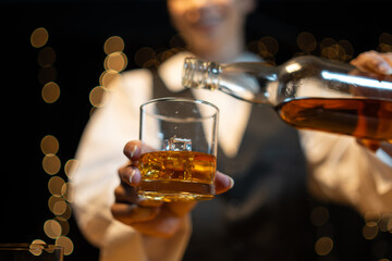 Barwoman pouring whiskey whiskey glass..