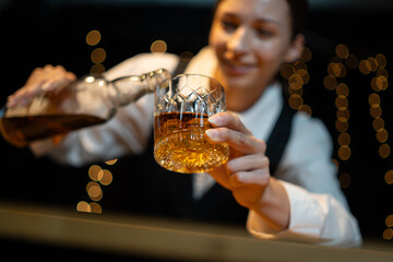 Barwoman pouring whiskey whiskey glass..
