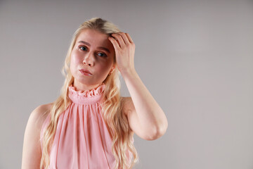 Fototapeta premium Portrait of beautiful young blonde woman in pink dress