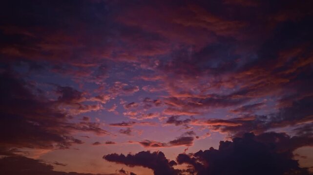 Beautiful sunset sky above clouds with dramatic light. Sunset with sun and clouds on blue and orange dramatic sky with sun rays. Night Sky timelapse. Moving clouds at sunset. Evening Clouds.