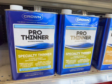 Cans of Crown brand Pro Paint Thinner on a shelf of paint store.