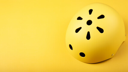 Fototapeta premium Yellow helmet on yellow color background. Child's outdoors activity safety protection: rollers, bicycle, skateboard