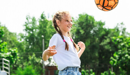 Kids play football on outdoor stadium field. Children score a goal during soccer game. Little girl kicking ball.