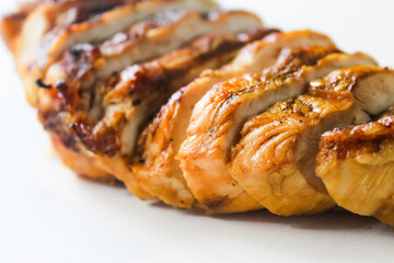 close-up of grilled chicken breast slices on white background