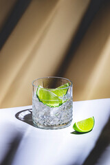 Strong alcoholic cocktail drink with craft rum, sugar syrup and lime. Beige background