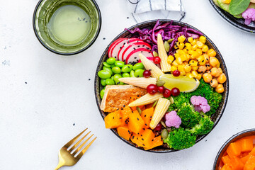 Vegan buddha bowl for balanced diet with pumpkin, quinoa, radish, edamame, tofu, broccoli, corn, chickpeas and sesame seeds, white background, top view