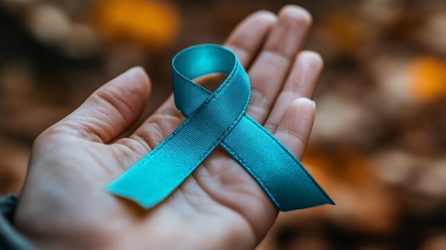 Teal ribbon on a woman's hand, showcasing support for ovarian cancer and PCOS awareness, with a focus on health advocacy.