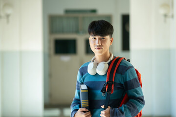 Portrait of male college student at campus looking at camera.