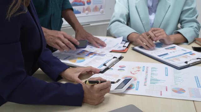 A businessperson, holding hands, cooperate during a corporate meeting.  review a graph document together, discussing strategies and financial data to achieve successful outcomes and effective