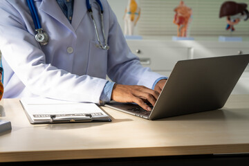 A male doctor sits at a desk in the heart clinic, consulting online and giving advice. The vascular...
