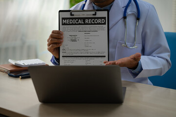 A male doctor sits at a desk in the heart clinic, consulting online and giving advice. The vascular surgery clinic offers an electrocardiogram service with modern technology and expert care.
