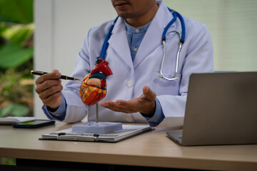 A male doctor sits at a desk in the heart clinic, consulting online and giving advice. The vascular...