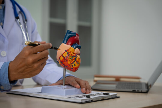 A male doctor sits at a desk in the heart clinic, consulting online and giving advice. The vascular surgery clinic offers an electrocardiogram service with modern technology and expert care. - Powered by Adobe