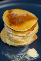 milk pancakes with butter on a blue plate