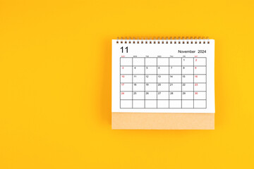 November 2024 desk calendar on yellow color background, position with copy space.