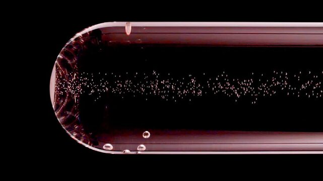 Close up tablet of aspirin, vitamin falls into of water in glass test tube in slow motion on black background. Macro shot of bubbles effervescent. The medicine concept, health care, treatment.FullHD 