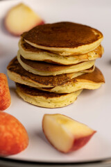 milk pancakes with butter and sliced peach slices