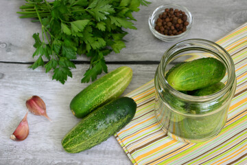 a jar of cucumber next to some other vegetables preserves 