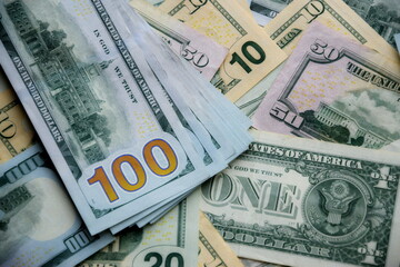 Big amount of US dollar bills in different nominations on table. Many dollar banknotes under natural light