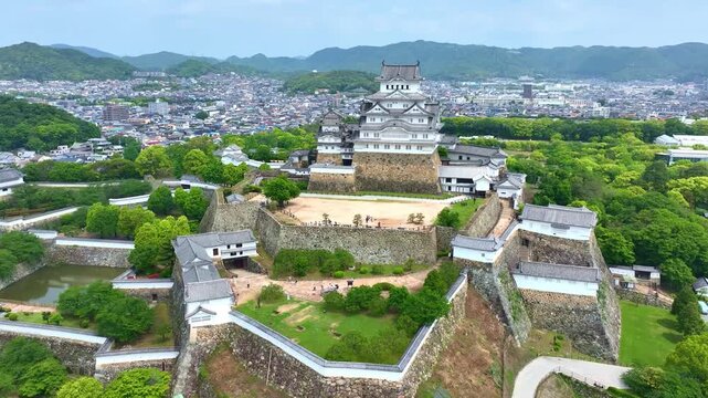 tilt down shot of Himeji castle in Japan, aerial view of a traditional Japanese samurai fort in Hyogo prefecture, travel in Japan, medieval castle of Himeji drone view