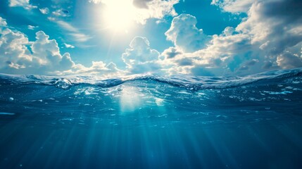 Blue sea or ocean water surface and underwater with sunny and cloudy sky