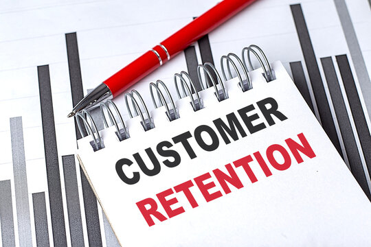 CUSTOMER RETENTION text on notebook on chart with pen